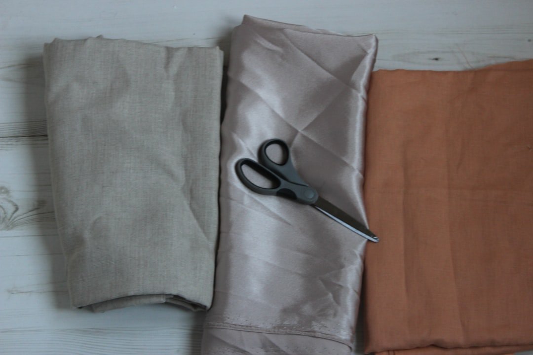 Soft sculptural burgundy leather tote bag with no visible branding held by fashionably dressed person